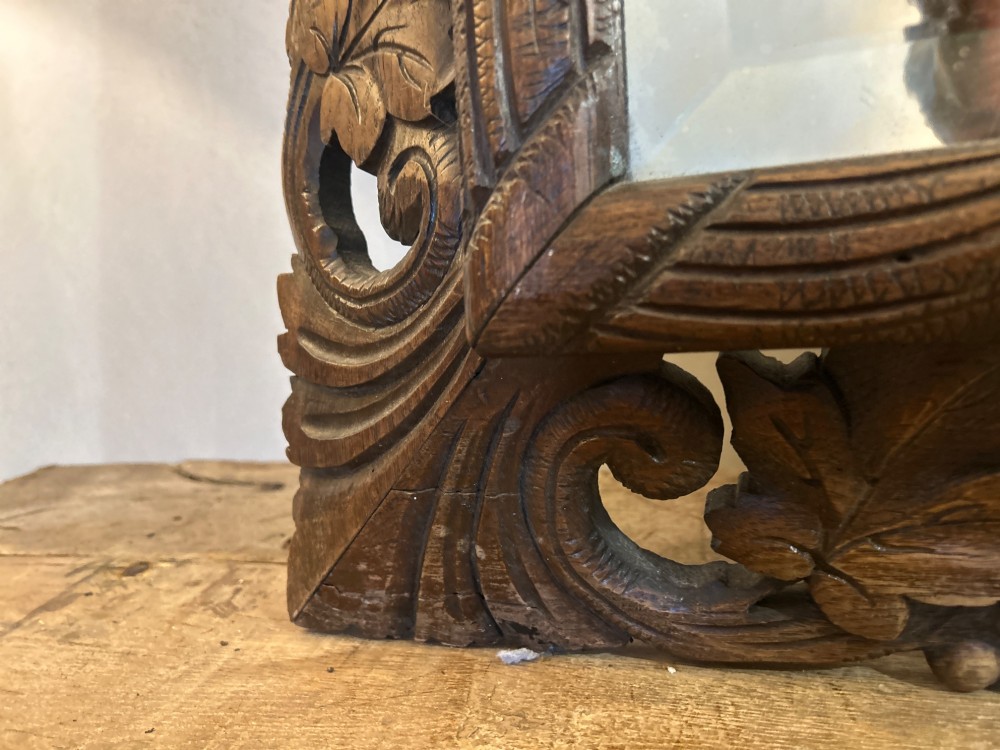 An ornate French oak wall mirror featuring intricate hand-carved leaf and grapevine motifs around a rectangular glass plate. View IX