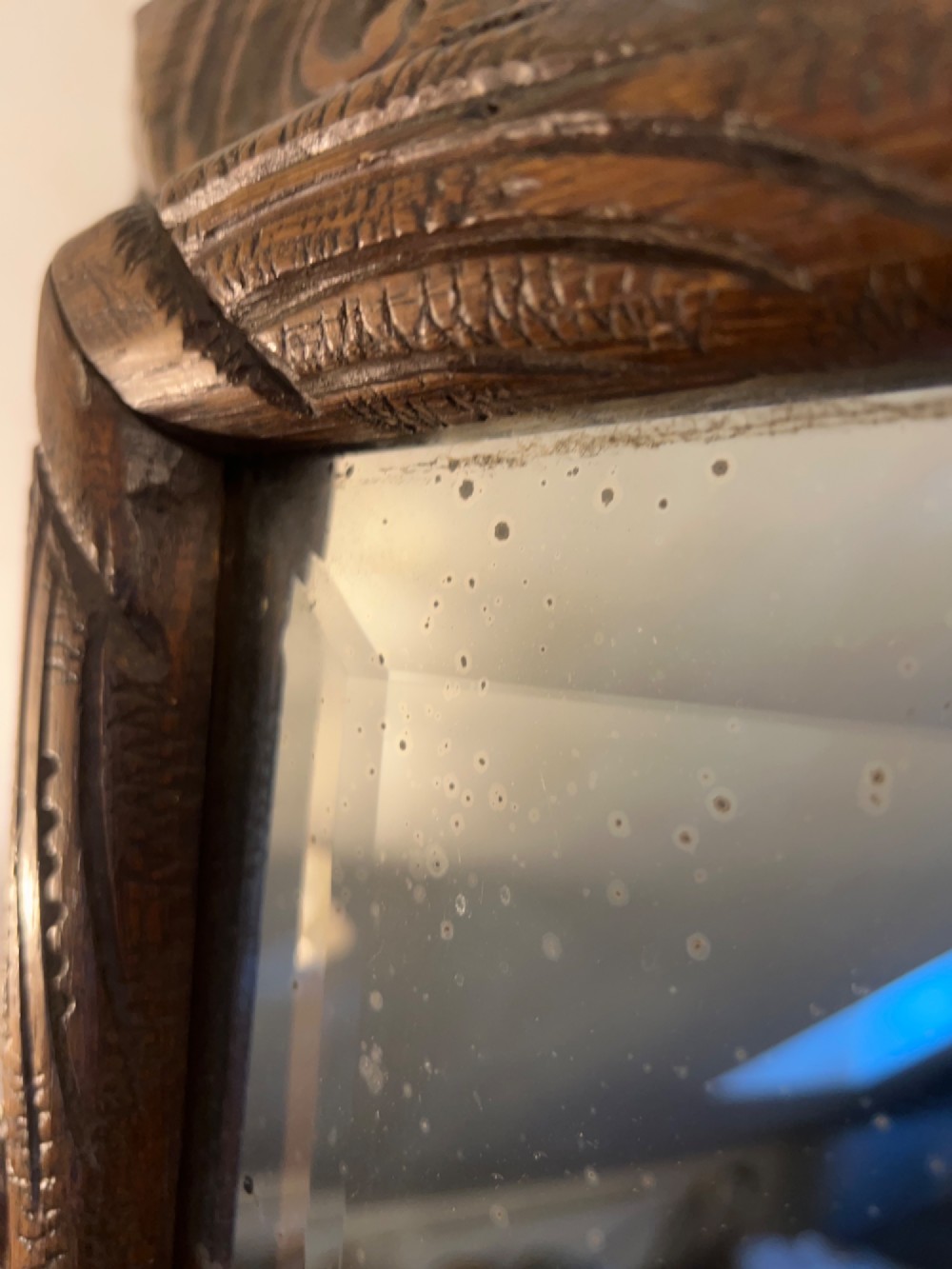 An ornate French oak wall mirror featuring intricate hand-carved leaf and grapevine motifs around a rectangular glass plate. View XII