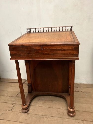 A Regency rosewood Davenport desk featuring an inclined leather-inlaid writing slope, a spindle top rail, side drawers, and turned front columns. View II