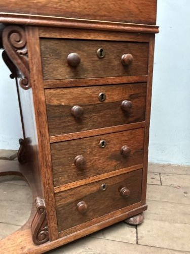 A Regency rosewood Davenport desk featuring an inclined leather-inlaid writing slope, a spindle top rail, side drawers, and turned front columns. View VII