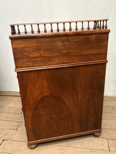 A Regency rosewood Davenport desk featuring an inclined leather-inlaid writing slope, a spindle top rail, side drawers, and turned front columns. View XII