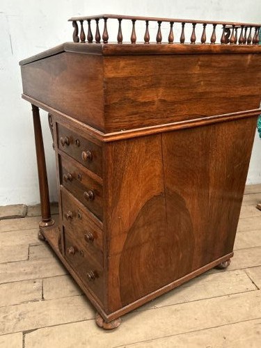 A Regency rosewood Davenport desk featuring an inclined leather-inlaid writing slope, a spindle top rail, side drawers, and turned front columns. View XIII