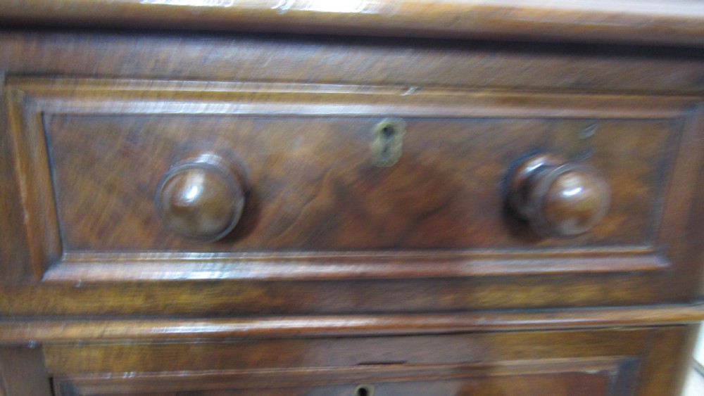 An antique mahogany pedestal desk featuring a red leather writing surface with gold tooling and nine drawers fitted with turned wooden handles. View XIV