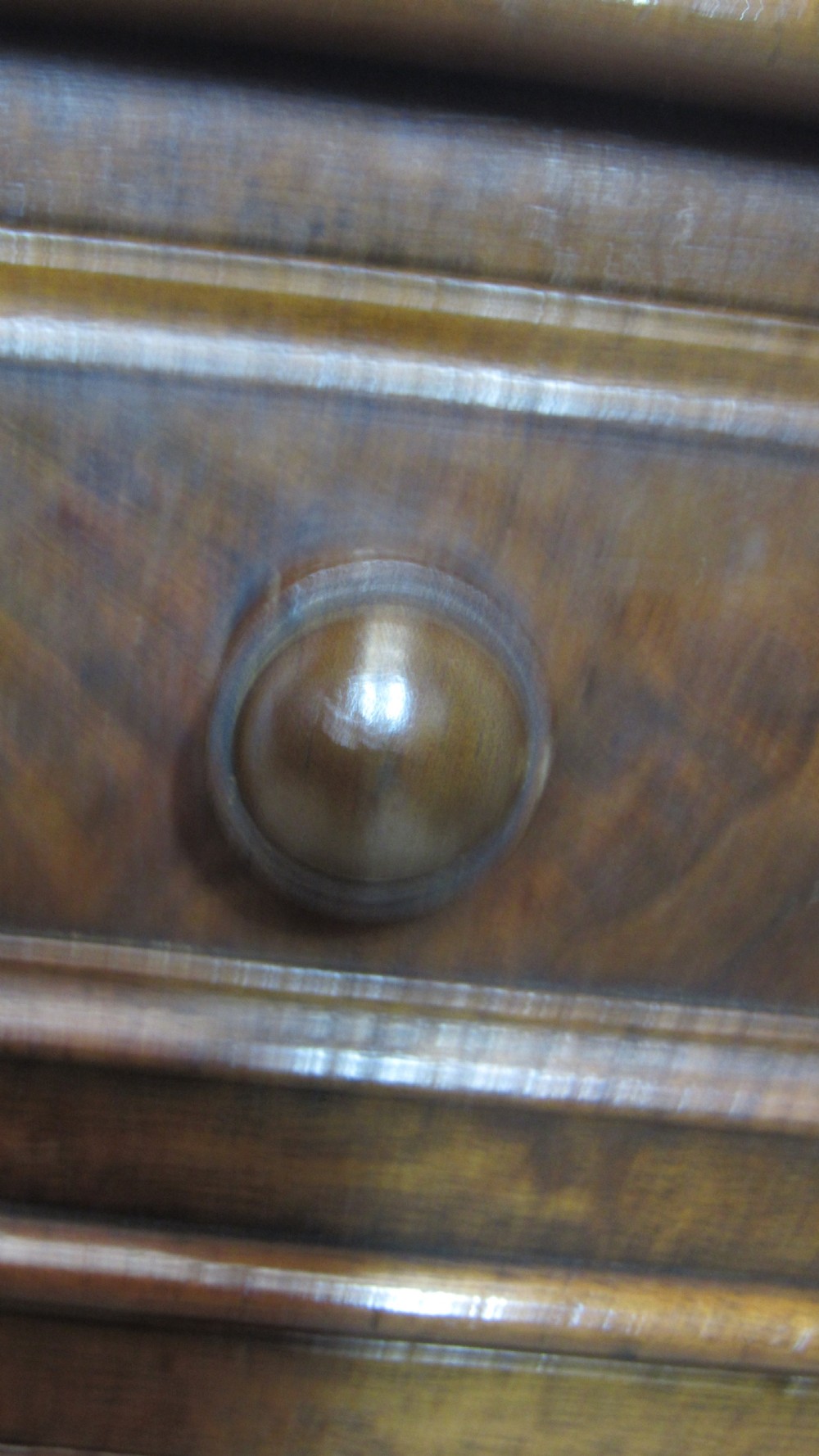 An antique mahogany pedestal desk featuring a red leather writing surface with gold tooling and nine drawers fitted with turned wooden handles. View XV