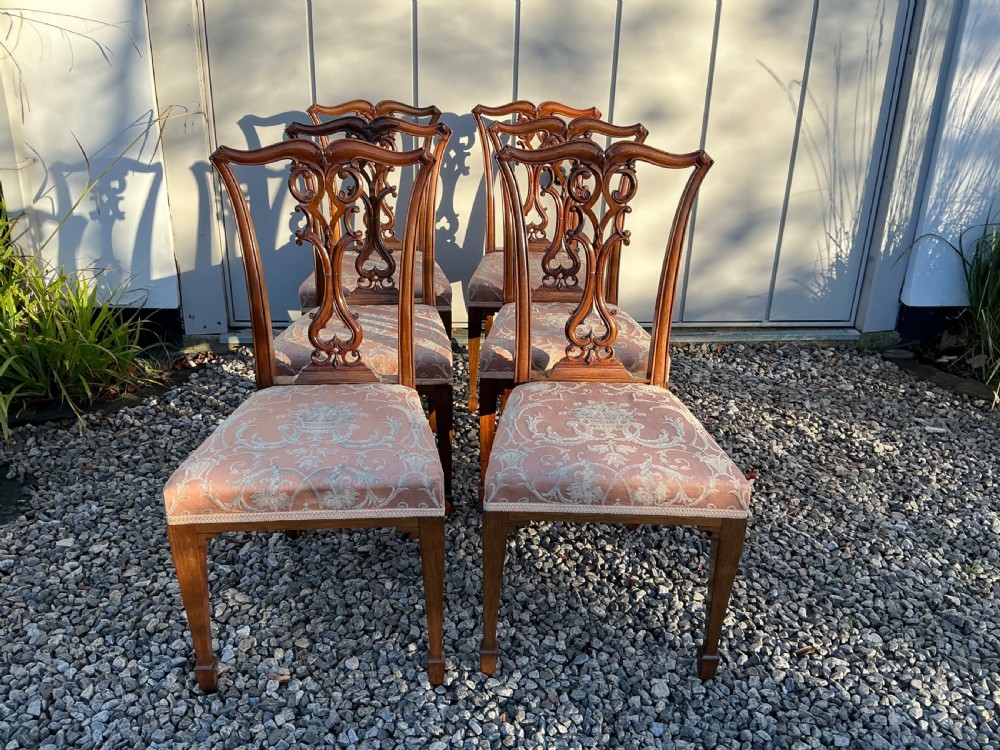 A set of eight mahogany Chippendale style dining chairs featuring elaborate pierced back splats and patterned upholstered seats. View XIII