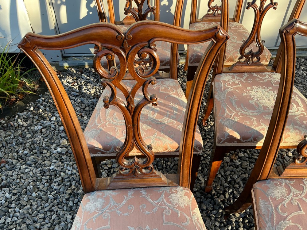 A set of eight mahogany Chippendale style dining chairs featuring elaborate pierced back splats and patterned upholstered seats. View XIV