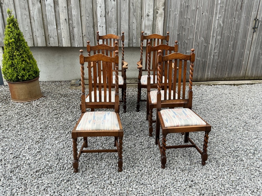 A set of six warm brown oak dining chairs, comprising two carver armchairs and four side chairs, featuring barley twist leg supports and vertical slatted backrests. View II