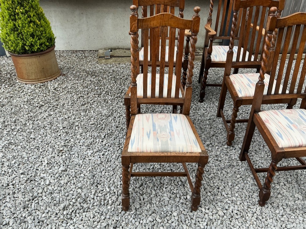 A set of six warm brown oak dining chairs, comprising two carver armchairs and four side chairs, featuring barley twist leg supports and vertical slatted backrests. View III
