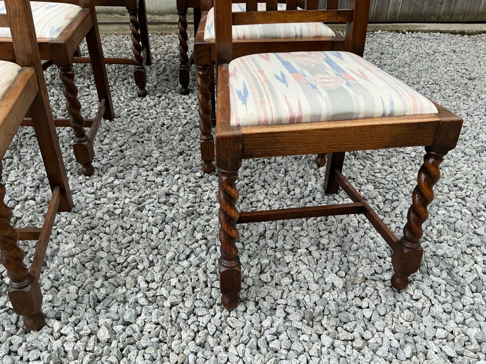 A set of six warm brown oak dining chairs, comprising two carver armchairs and four side chairs, featuring barley twist leg supports and vertical slatted backrests. View IV
