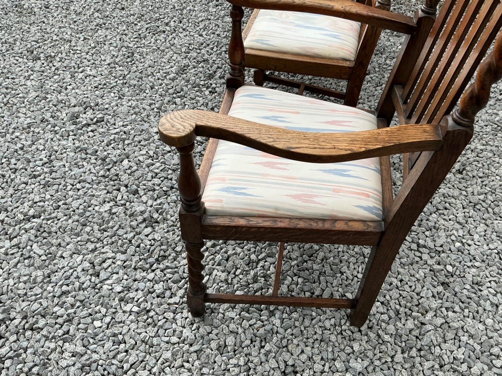 A set of six warm brown oak dining chairs, comprising two carver armchairs and four side chairs, featuring barley twist leg supports and vertical slatted backrests. View VIII