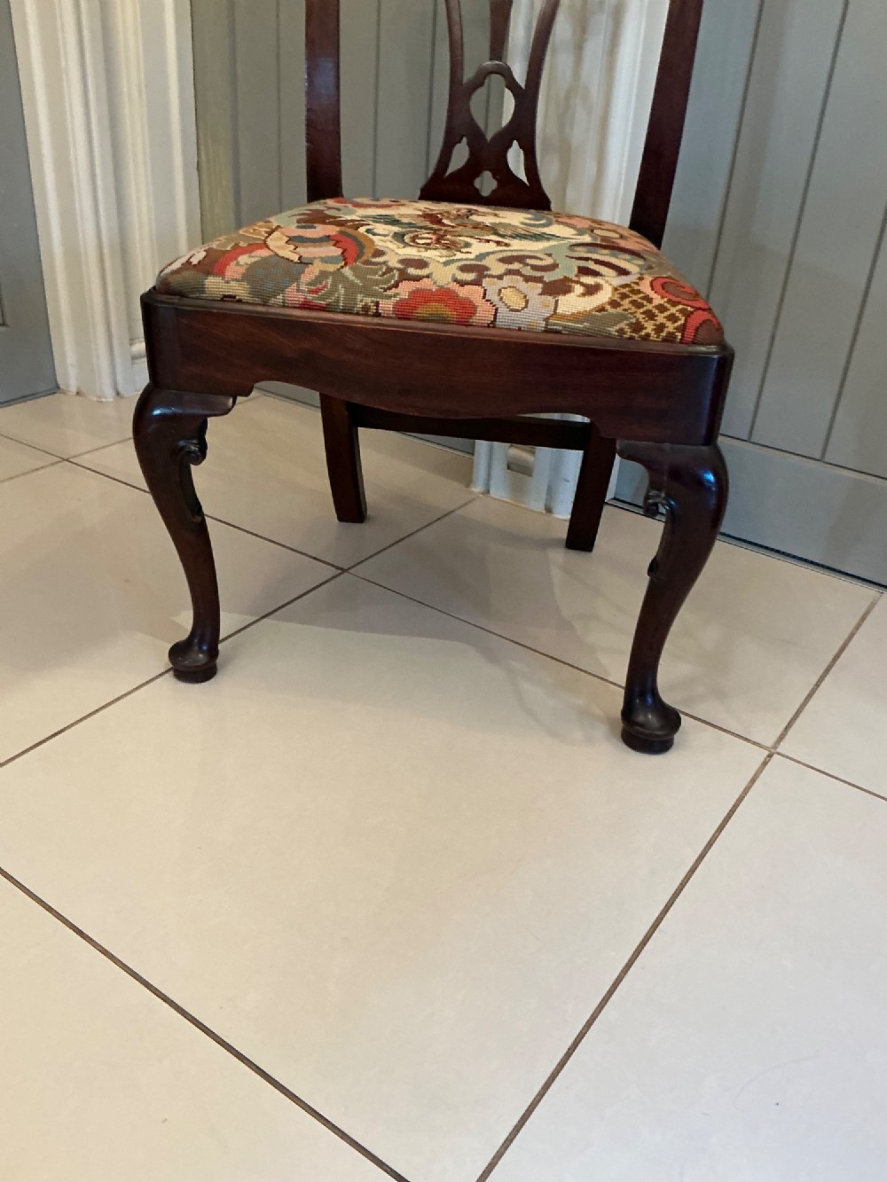 A Georgian mahogany side chair featuring a carved pierced splat back, cabriole front legs, and a needlepoint drop-in seat with a bird pattern. View VI