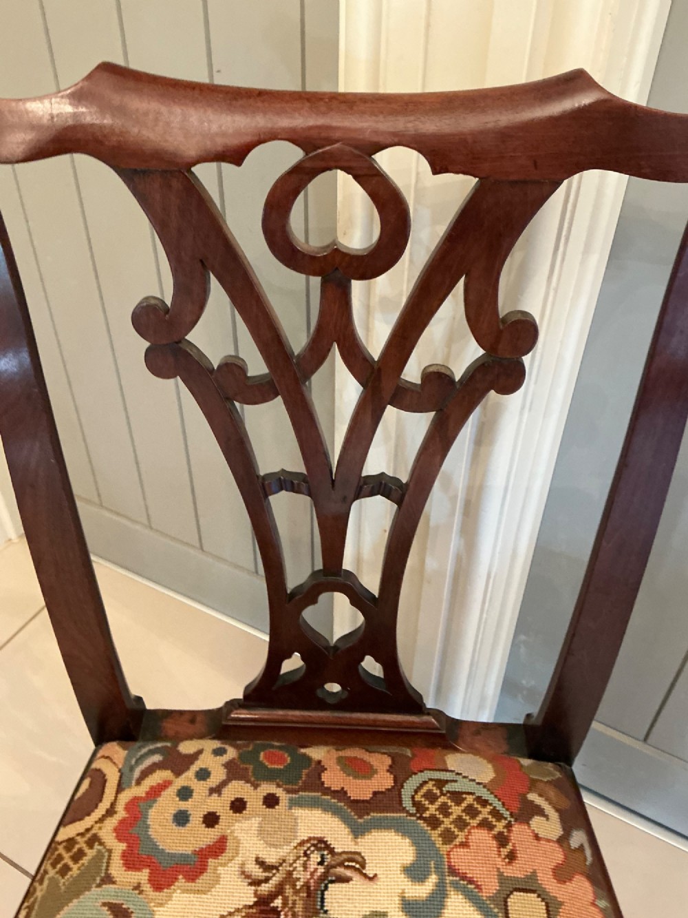 A Georgian mahogany side chair featuring a carved pierced splat back, cabriole front legs, and a needlepoint drop-in seat with a bird pattern. View VII
