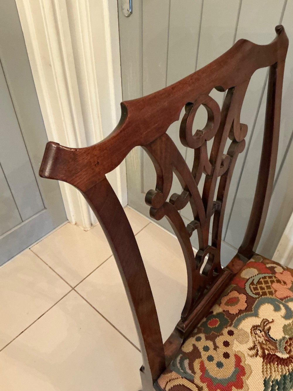 A Georgian mahogany side chair featuring a carved pierced splat back, cabriole front legs, and a needlepoint drop-in seat with a bird pattern. View IX