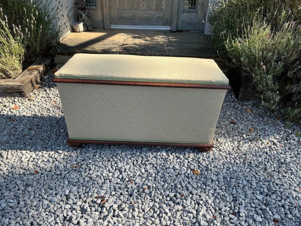 A rectangular Victorian upholstered ottoman featuring cream patterned fabric, polished mahogany rim moulding, and a low timber base. View II