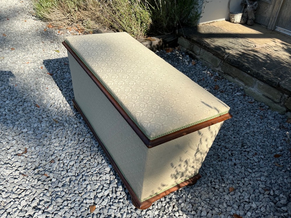A rectangular Victorian upholstered ottoman featuring cream patterned fabric, polished mahogany rim moulding, and a low timber base. View IV