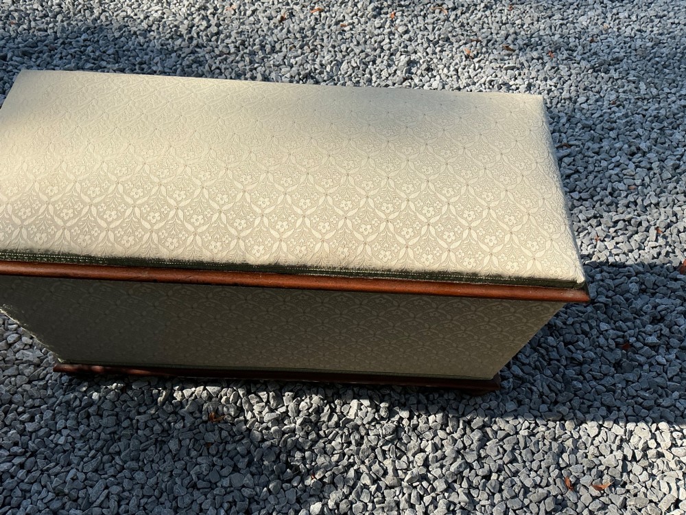 A rectangular Victorian upholstered ottoman featuring cream patterned fabric, polished mahogany rim moulding, and a low timber base. View VI