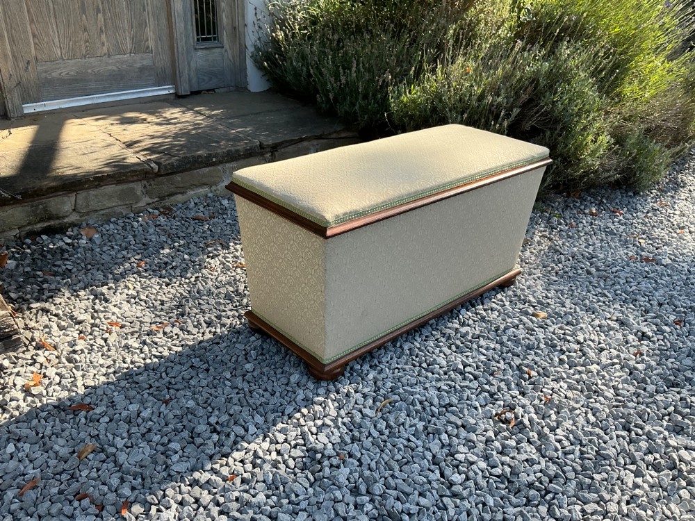 A rectangular Victorian upholstered ottoman featuring cream patterned fabric, polished mahogany rim moulding, and a low timber base. View VIII