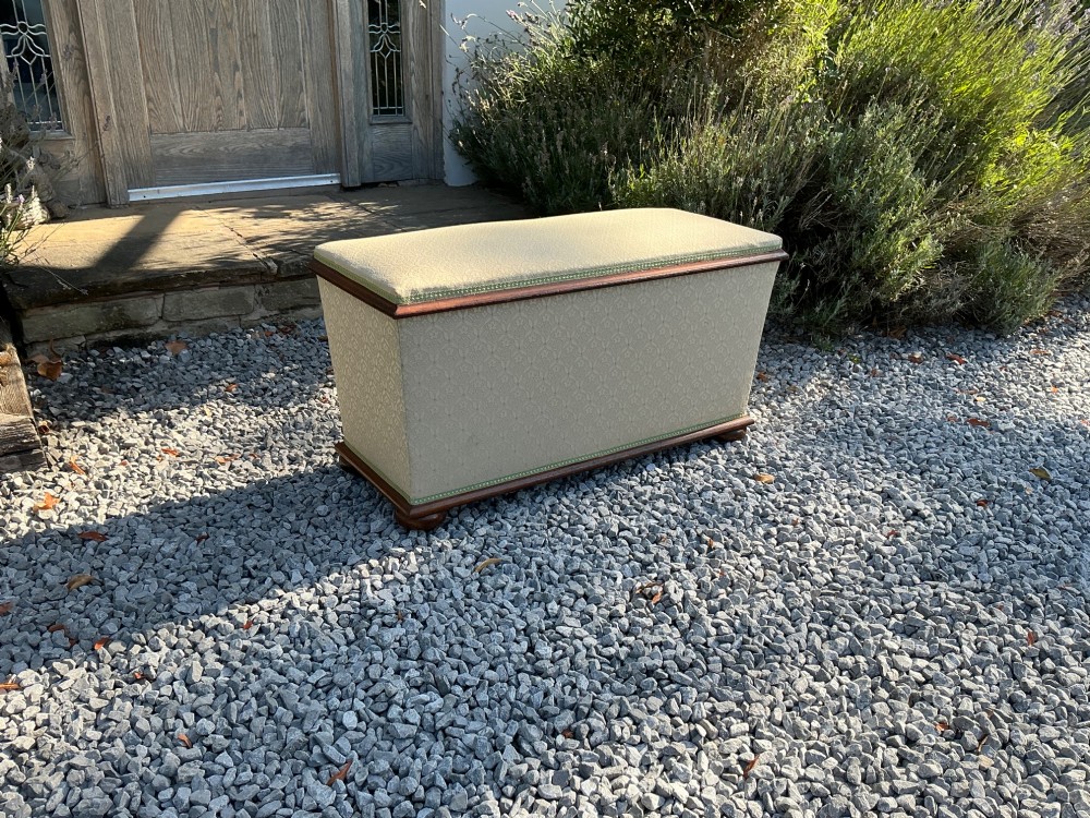 A rectangular Victorian upholstered ottoman featuring cream patterned fabric, polished mahogany rim moulding, and a low timber base. View IX