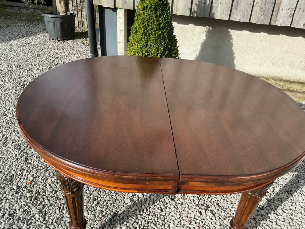 A large Victorian mahogany extending dining table with rounded ends, removable insert leaf, carved legs, and a rich polished finish. View XI