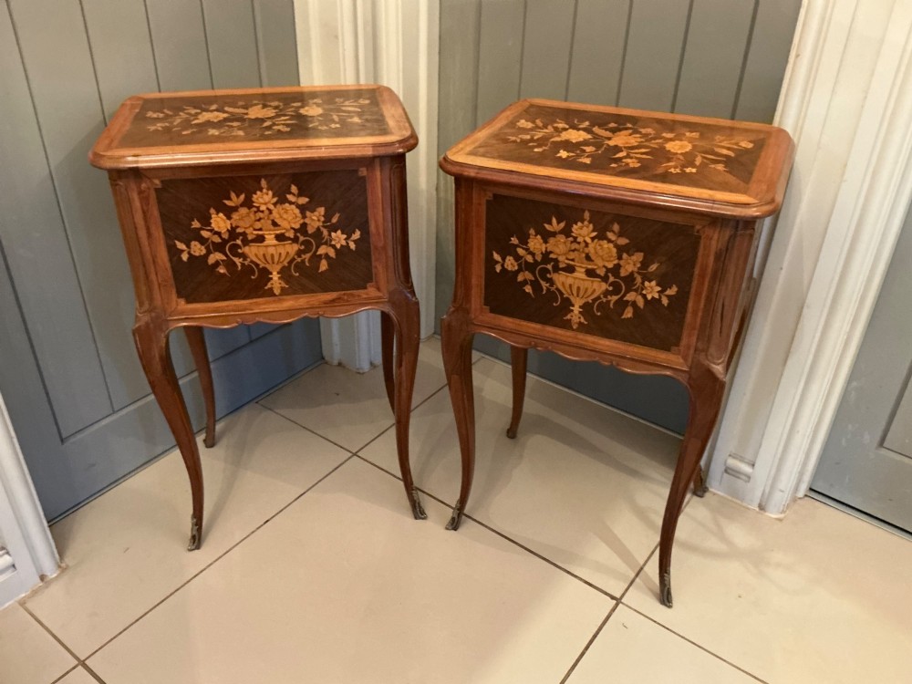 A pair of French Louis XV style wooden bedside tables decorated with intricate floral marquetry inlays and supported by cabriole legs with metal sabots. View II