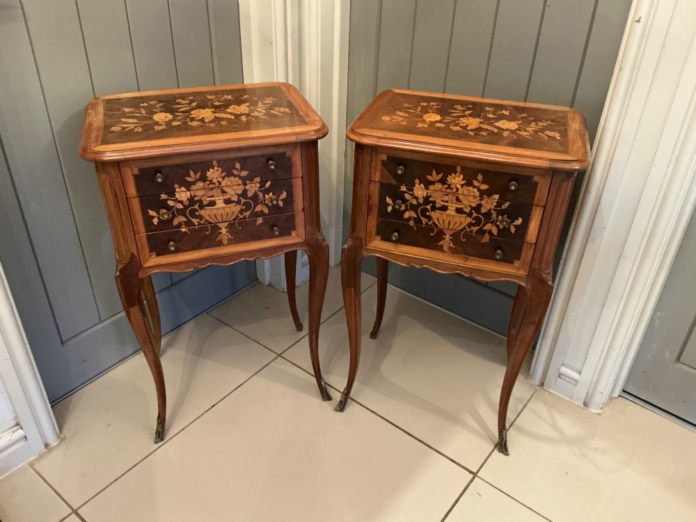 A pair of French Louis XV style wooden bedside tables decorated with intricate floral marquetry inlays and supported by cabriole legs with metal sabots. View IV