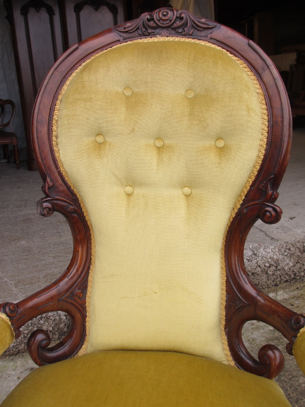 A Victorian walnut open armchair featuring a curved spoon back with button-tufted yellow velvet upholstery and carved cabriole legs. View III
