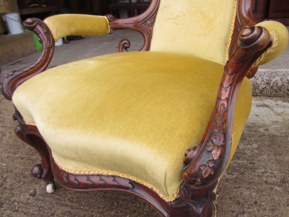 A Victorian walnut open armchair featuring a curved spoon back with button-tufted yellow velvet upholstery and carved cabriole legs. View IV