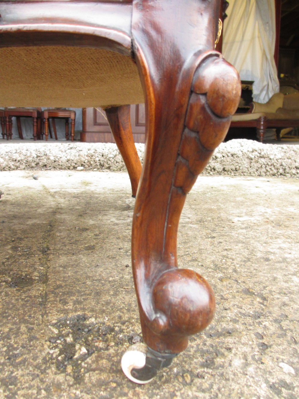 A Victorian walnut open armchair featuring a curved spoon back with button-tufted yellow velvet upholstery and carved cabriole legs. View X
