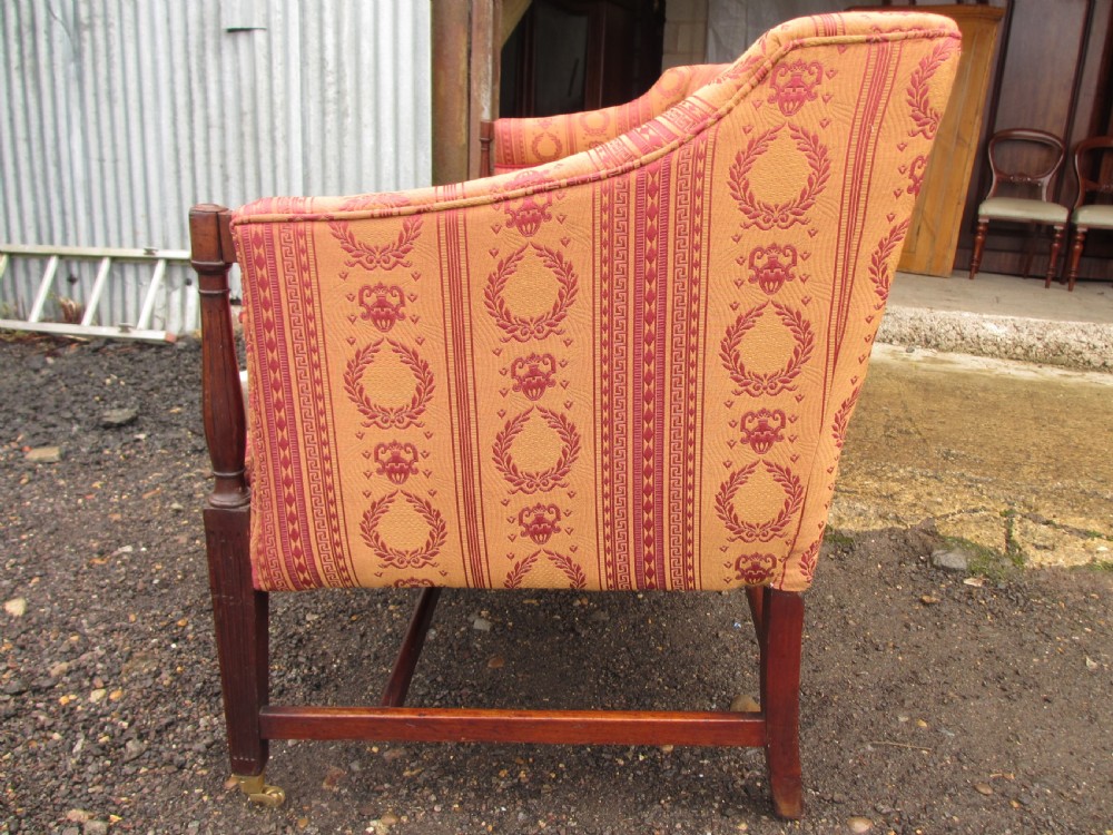 A Regency mahogany framed sofa upholstered in patterned red and gold fabric with reeded legs and brass castors. View XII