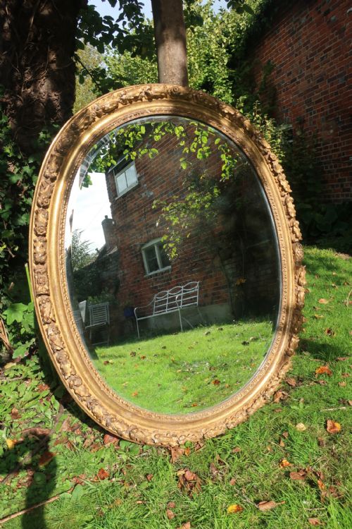 A Large Oval 18th Century Carved Giltwood Mirror