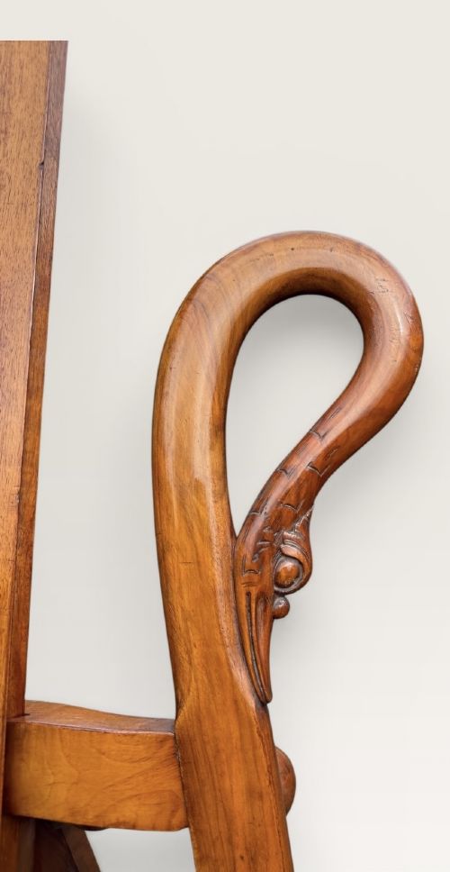 A tall warm brown wooden floor-standing tripod easel featuring carved swan head finials at the top arch and a wide horizontal support shelf. View IV