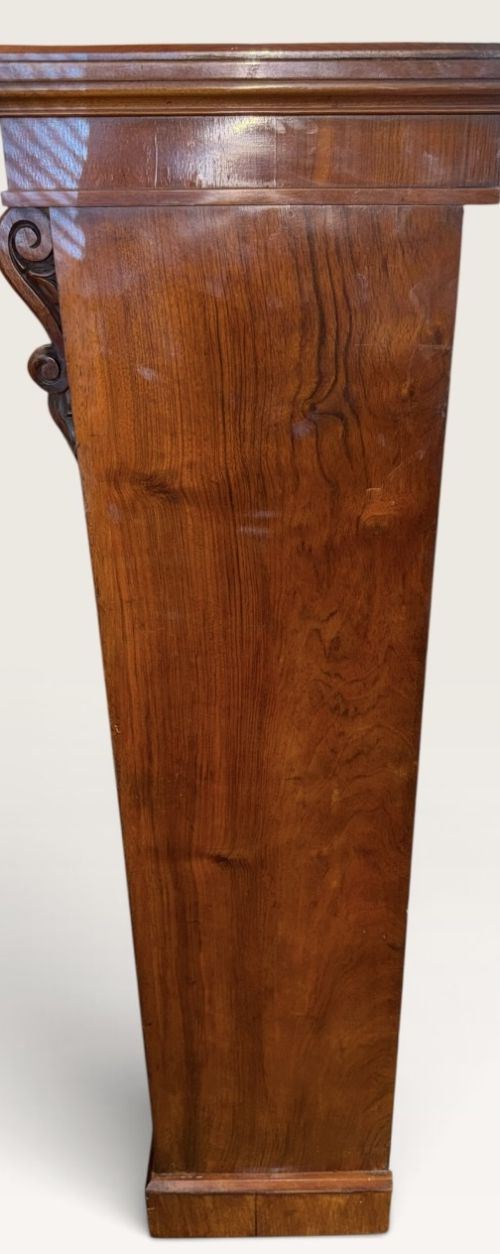 A 19th-century Victorian open walnut bookcase featuring four tiers, decorative carved corbels beneath a moulded top cornice, and a solid plinth base. View IV