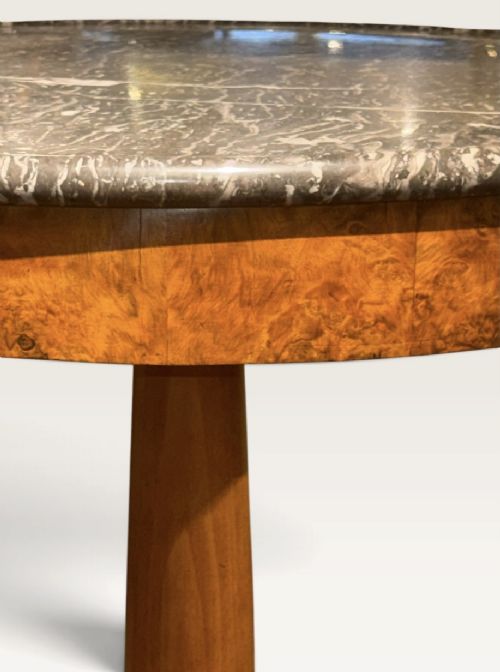 A circular antique centre table featuring a grey veined marble top, burr walnut veneered apron, a central turned column, and a triform platform base. View IV