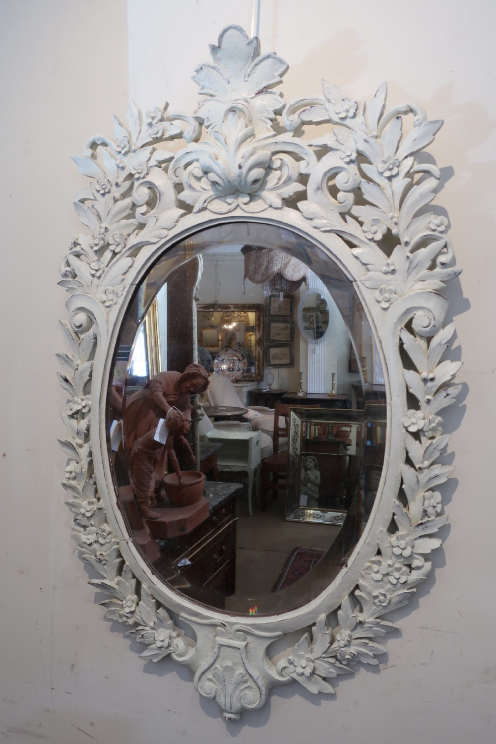 A very pretty carved and painted oval mirror