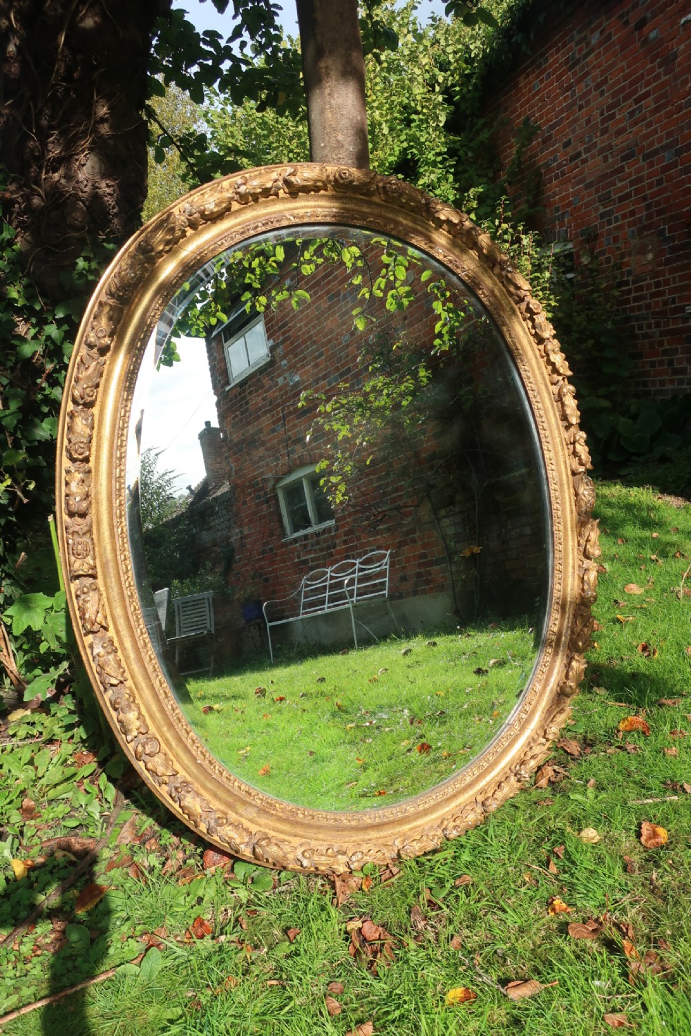 A large oval 18th Century carved giltwood mirror 