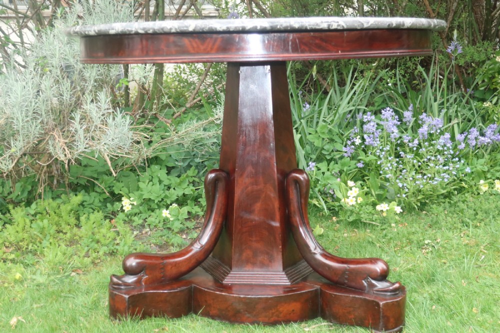 Flame mahogany Gueridon with dolphin decoration.