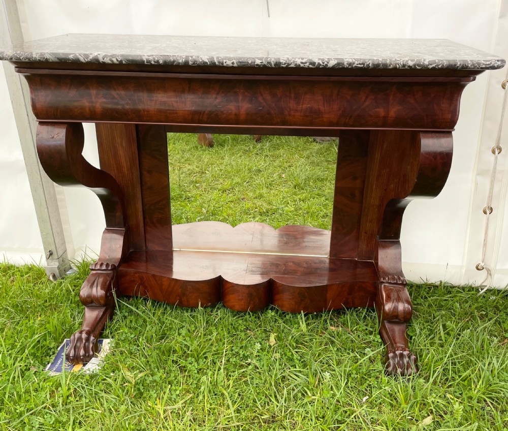 A 19th-century French Louis Philippe console table with flame mahogany veneer, a grey marble top, scrolled front supports, carved claw feet, and a mirrored back. View V