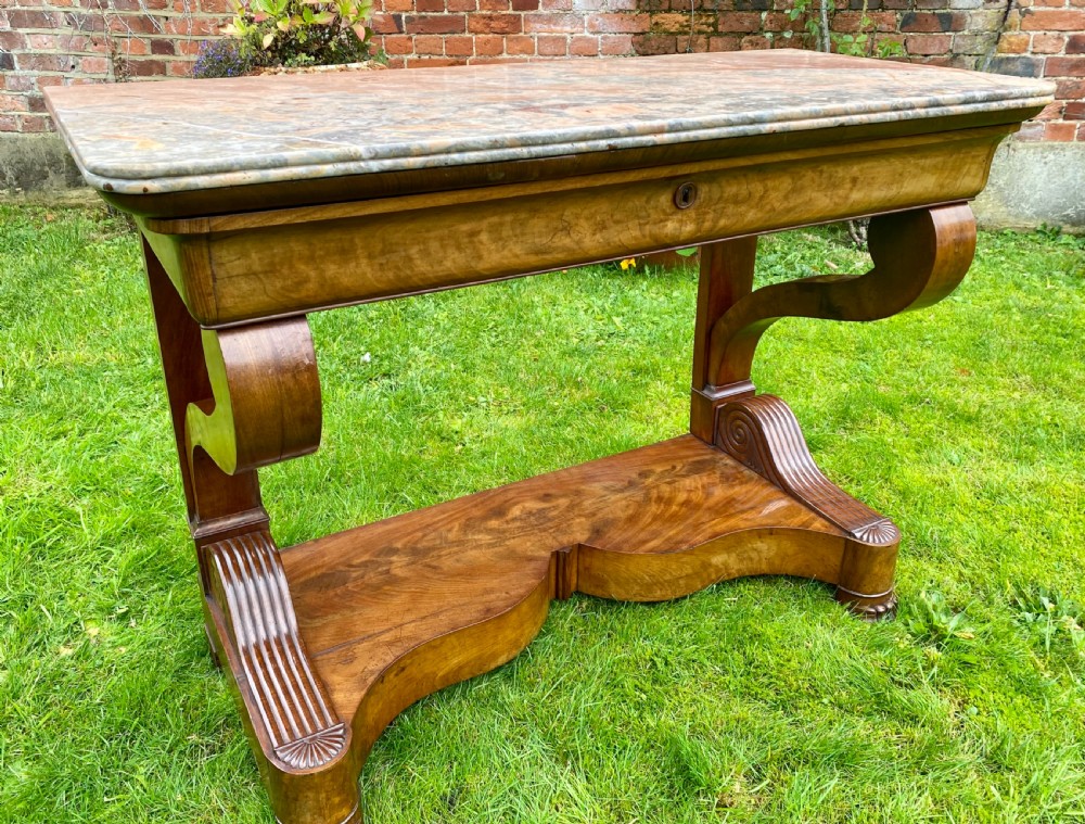 A 19th-century French Restauration figured walnut console table with a variegated grey marble top and S-scroll pedestal supports. View II