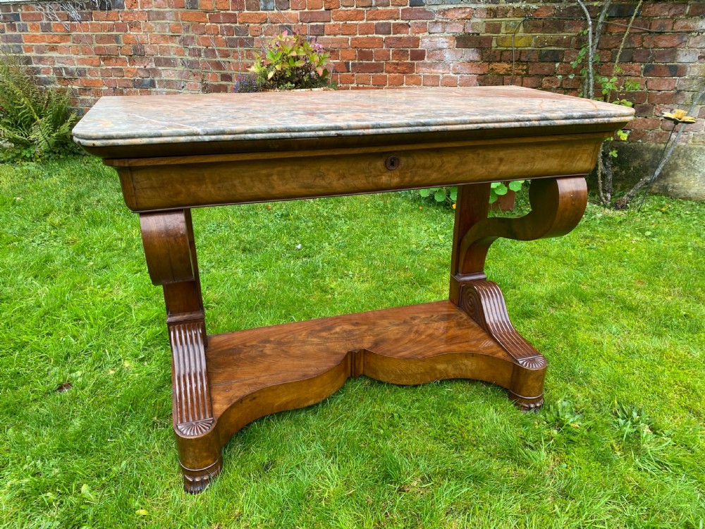 A 19th-century French Restauration figured walnut console table with a variegated grey marble top and S-scroll pedestal supports. View III