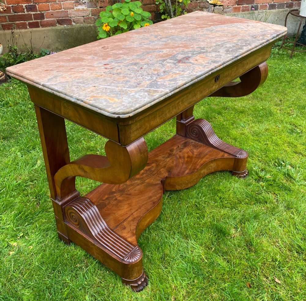 A 19th-century French Restauration figured walnut console table with a variegated grey marble top and S-scroll pedestal supports. View V