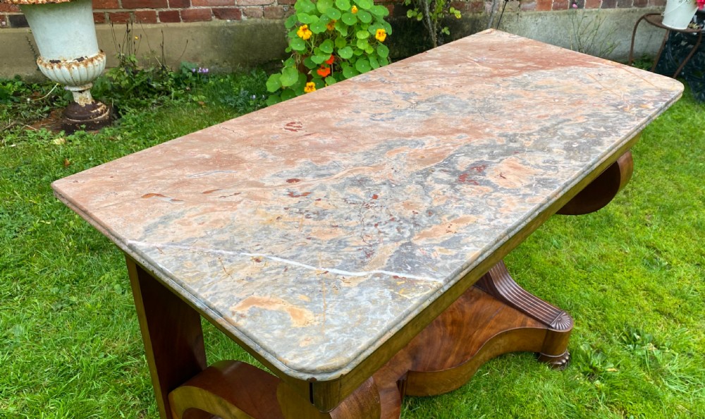 A 19th-century French Restauration figured walnut console table with a variegated grey marble top and S-scroll pedestal supports. View VI