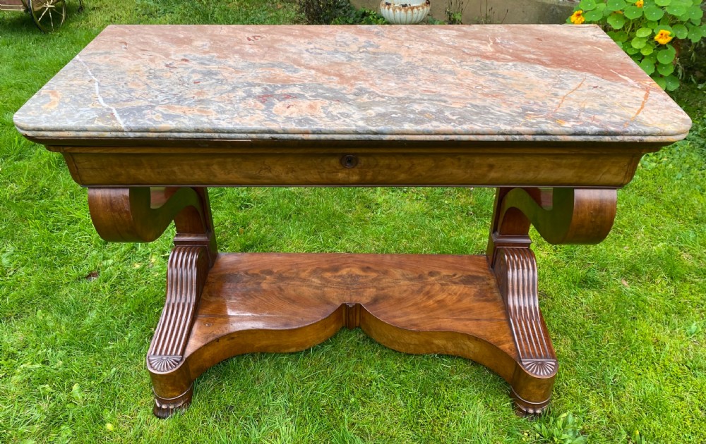 A 19th-century French Restauration figured walnut console table with a variegated grey marble top and S-scroll pedestal supports. View VII