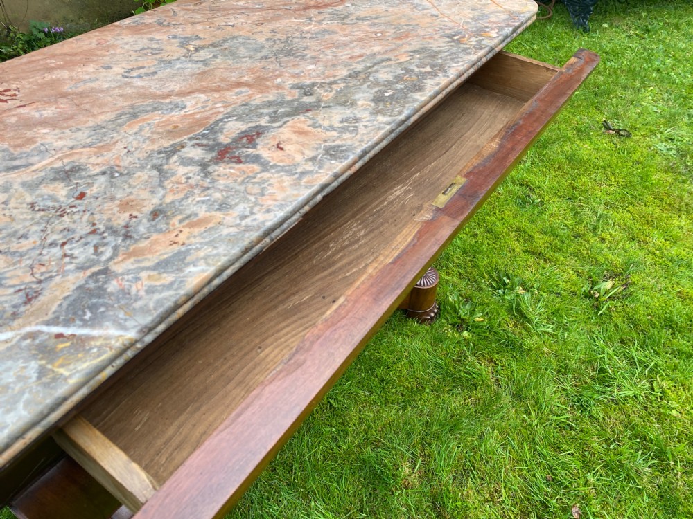 A 19th-century French Restauration figured walnut console table with a variegated grey marble top and S-scroll pedestal supports. View VIII