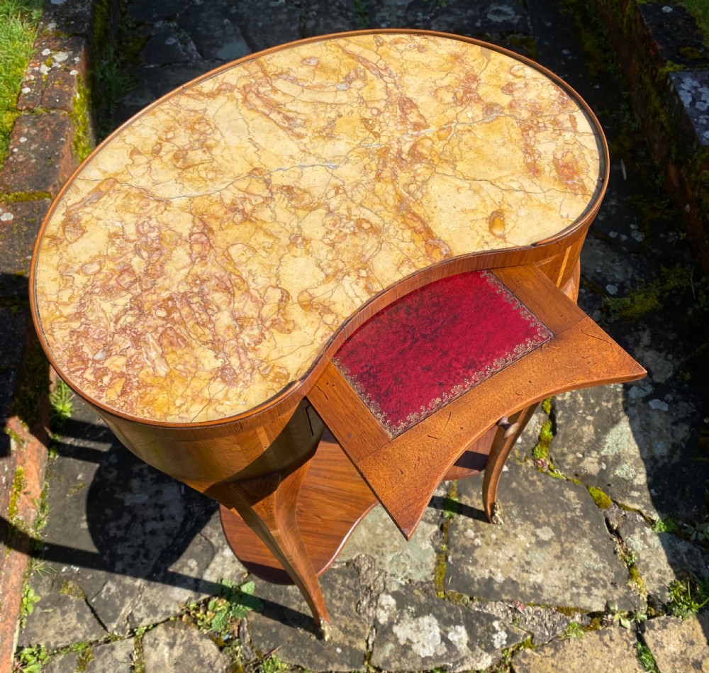 A kidney-shaped wood side table with chevron parquetry veneer, a single drawer with a brass handle, and an undertier shelf. View II