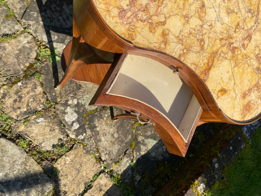 A kidney-shaped wood side table with chevron parquetry veneer, a single drawer with a brass handle, and an undertier shelf. View III