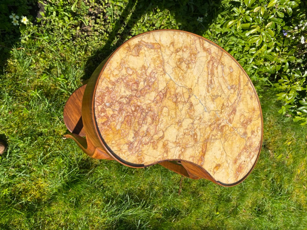 A kidney-shaped wood side table with chevron parquetry veneer, a single drawer with a brass handle, and an undertier shelf. View VII