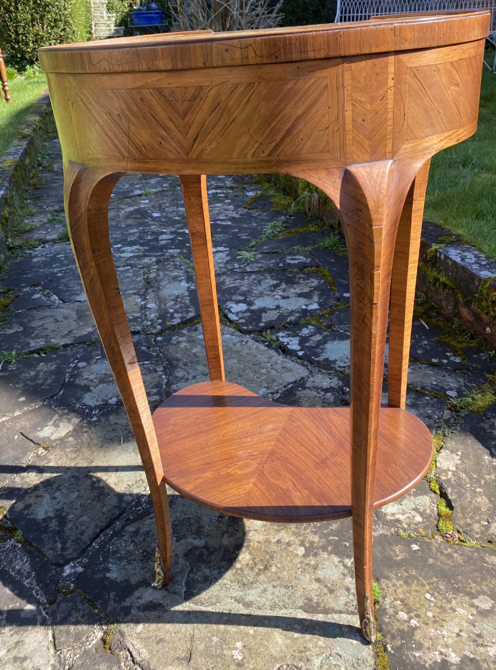 A kidney-shaped wood side table with chevron parquetry veneer, a single drawer with a brass handle, and an undertier shelf. View VIII
