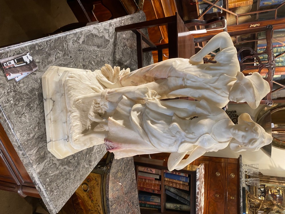A large carved cream alabaster and marble sculpture depicting a young man and woman in rural clothing standing on a naturalistic base. View III