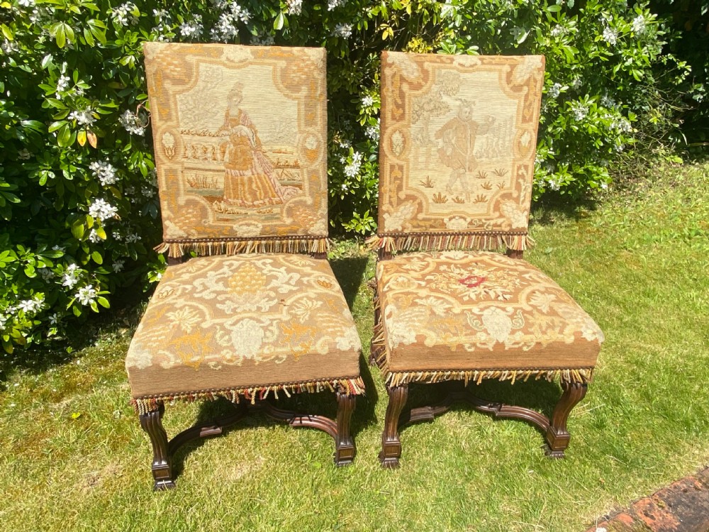 A pair of antique rosewood side chairs upholstered in detailed needlepoint fabric depicting figural scenes with fringed borders. View IV