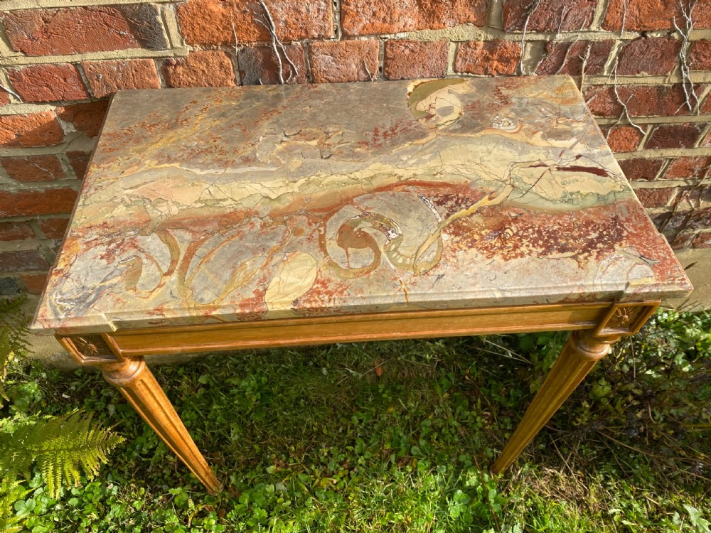 An 18th-century Neoclassical console table with a variegated marble top, carved apron, square corner rosettes, and fluted tapered legs. View III